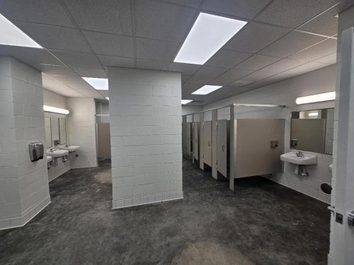 A spacious bathroom featuring multiple sinks and toilets, designed for functionality and comfort.